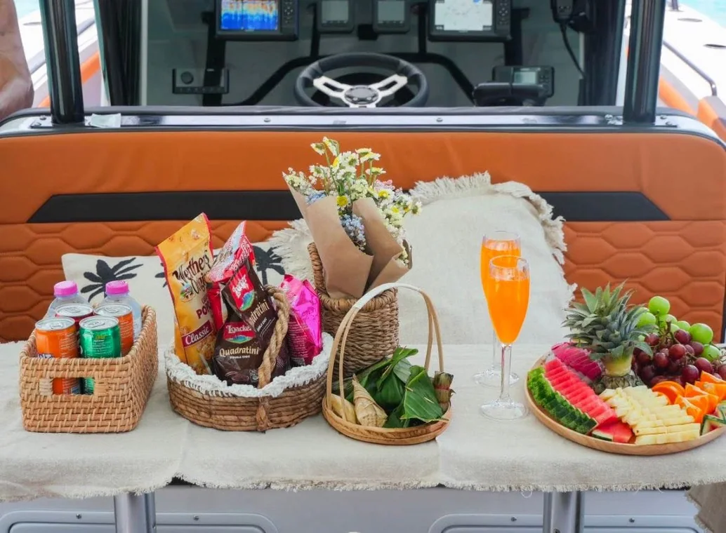 La table d'accueil dressée à bord : boissons fraîches, fruits, douceurs et fleurs