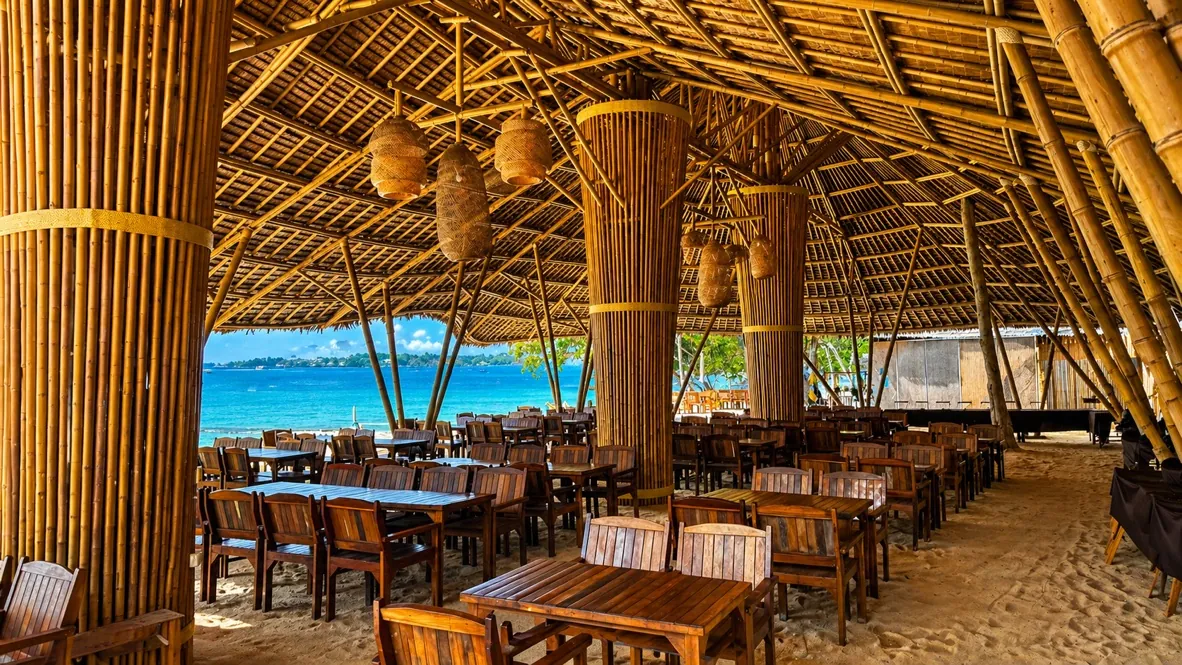 Salle de restaurant en bambou ouverte sur la plage et la mer