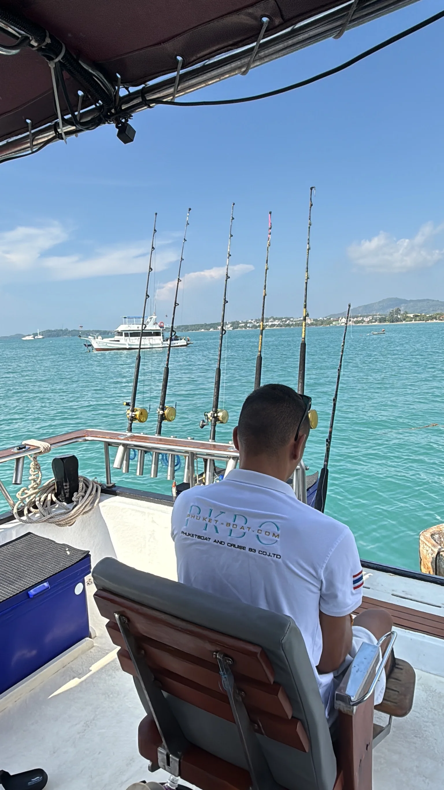 Cannes de traîne armées et sièges de combat à l'arrière du bateau de pêche