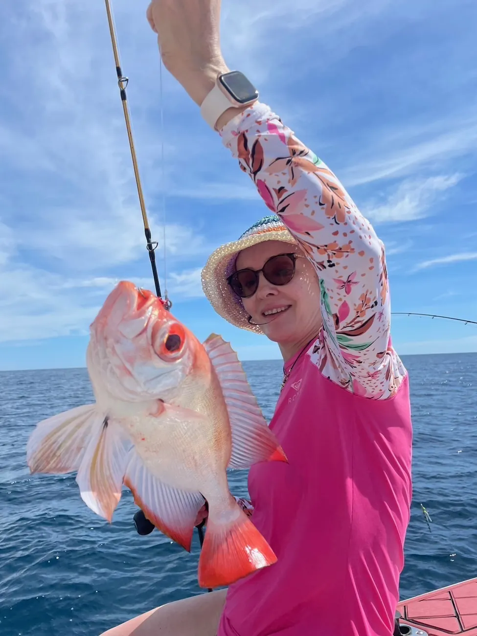 Une cliente montre le poisson rouge qu’elle vient de remonter à la canne