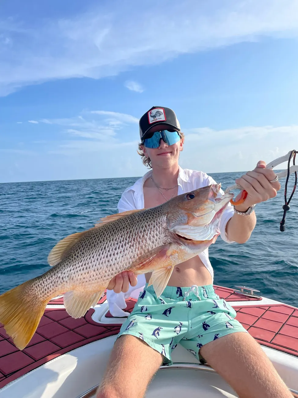 Un pêcheur présente un gros vivaneau pris à bord au large de Phuket