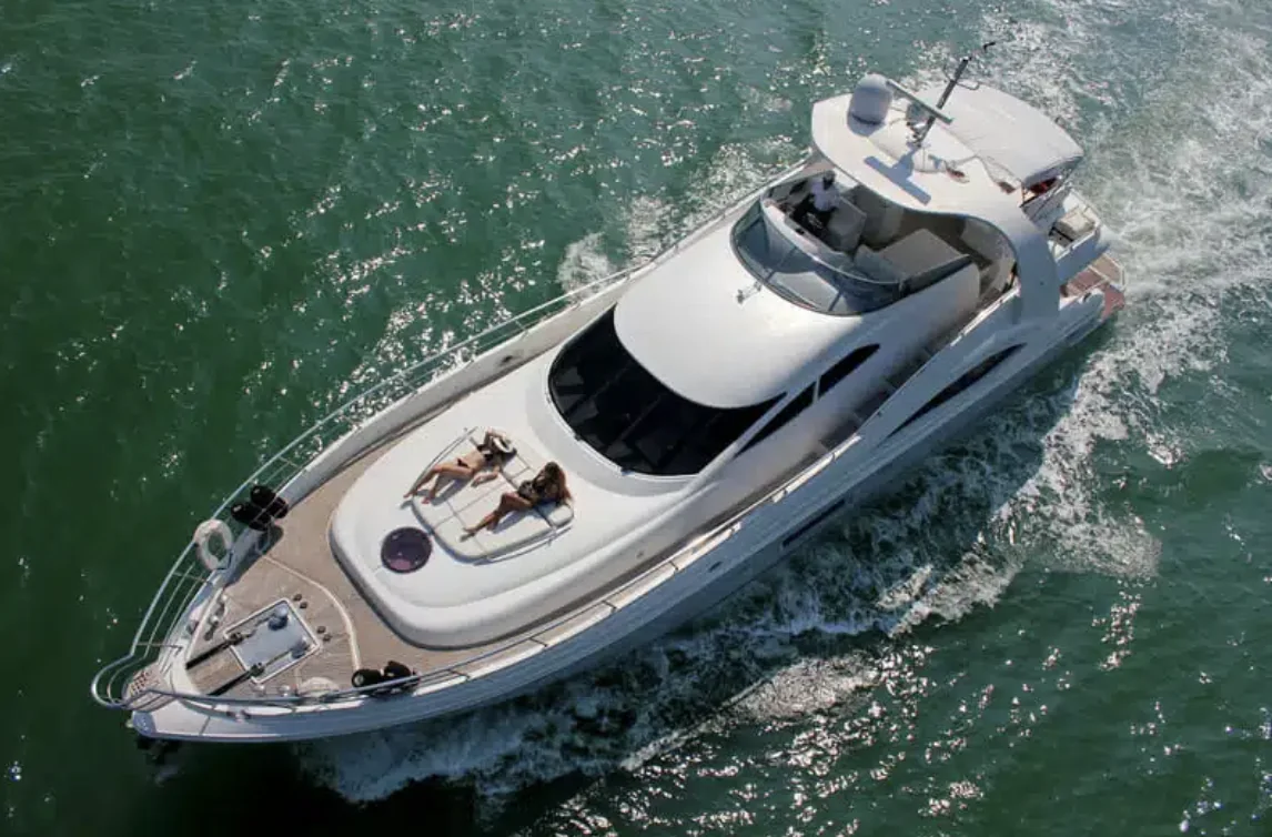 Vue aérienne du yacht en navigation, bain de soleil occupé sur la plage avant