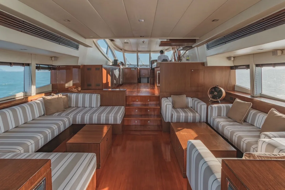 Le carré du yacht, banquettes et boiseries, ouvert sur le poste de pilotage